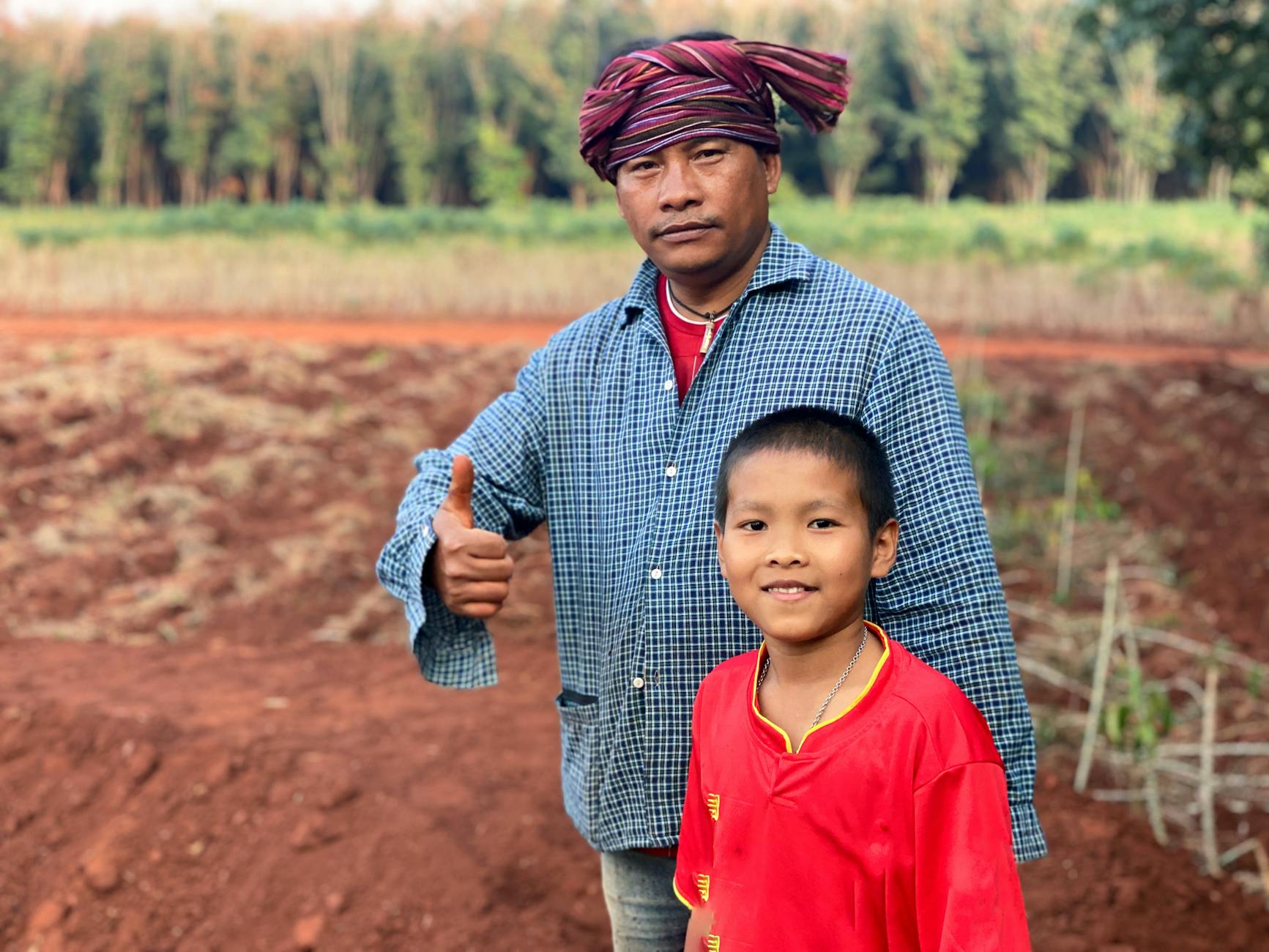 Ojciec z synem pracujący w polu w wiejskim regionie Isan w Tajlandii