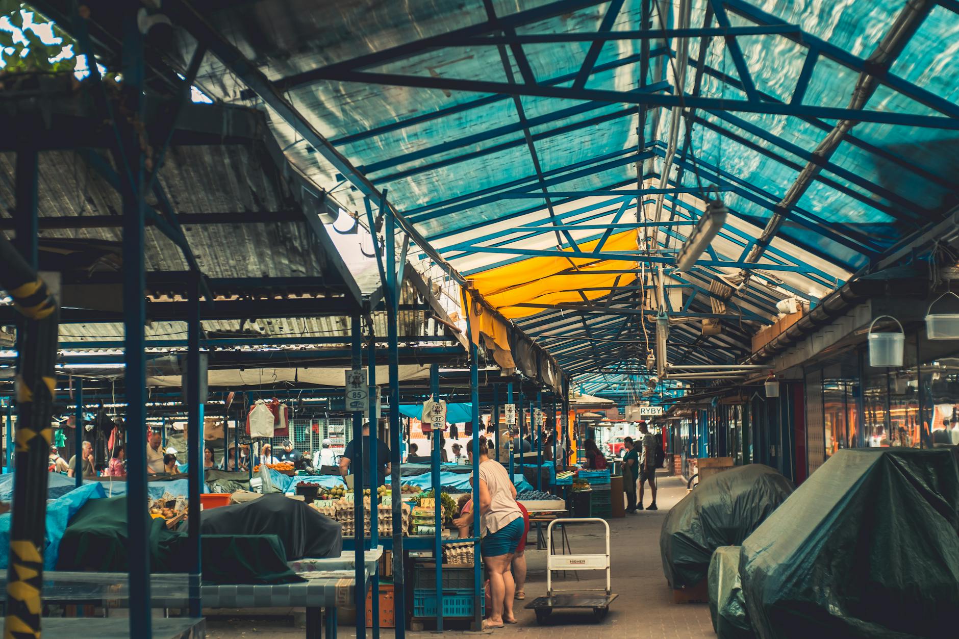 Kolorowe stragany na krakowskim targu pełnym lokalnych mieszkańców