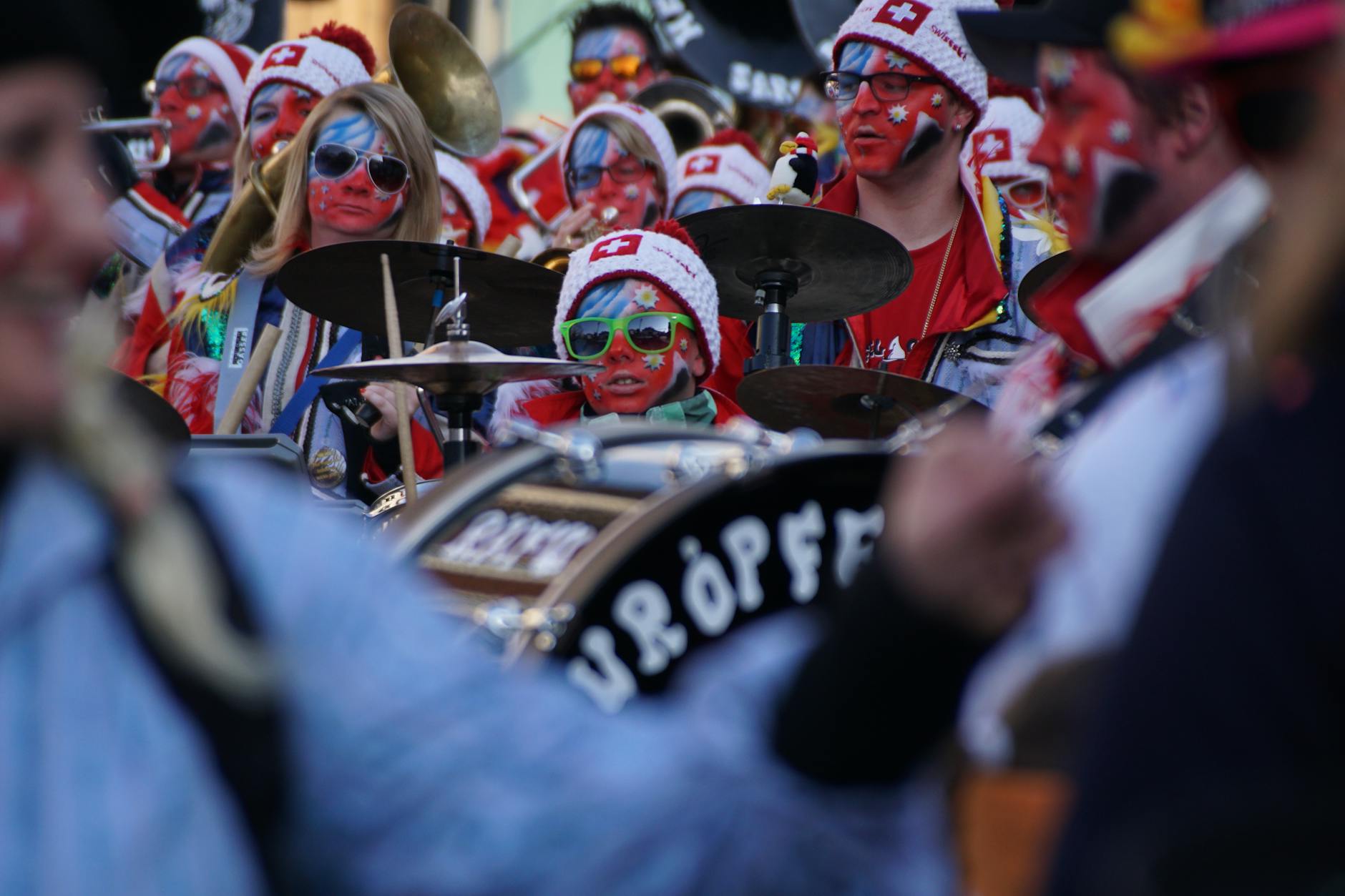 Kolorowy pochód bębniarzy z pomalowanymi twarzami w Muri w Szwajcarii