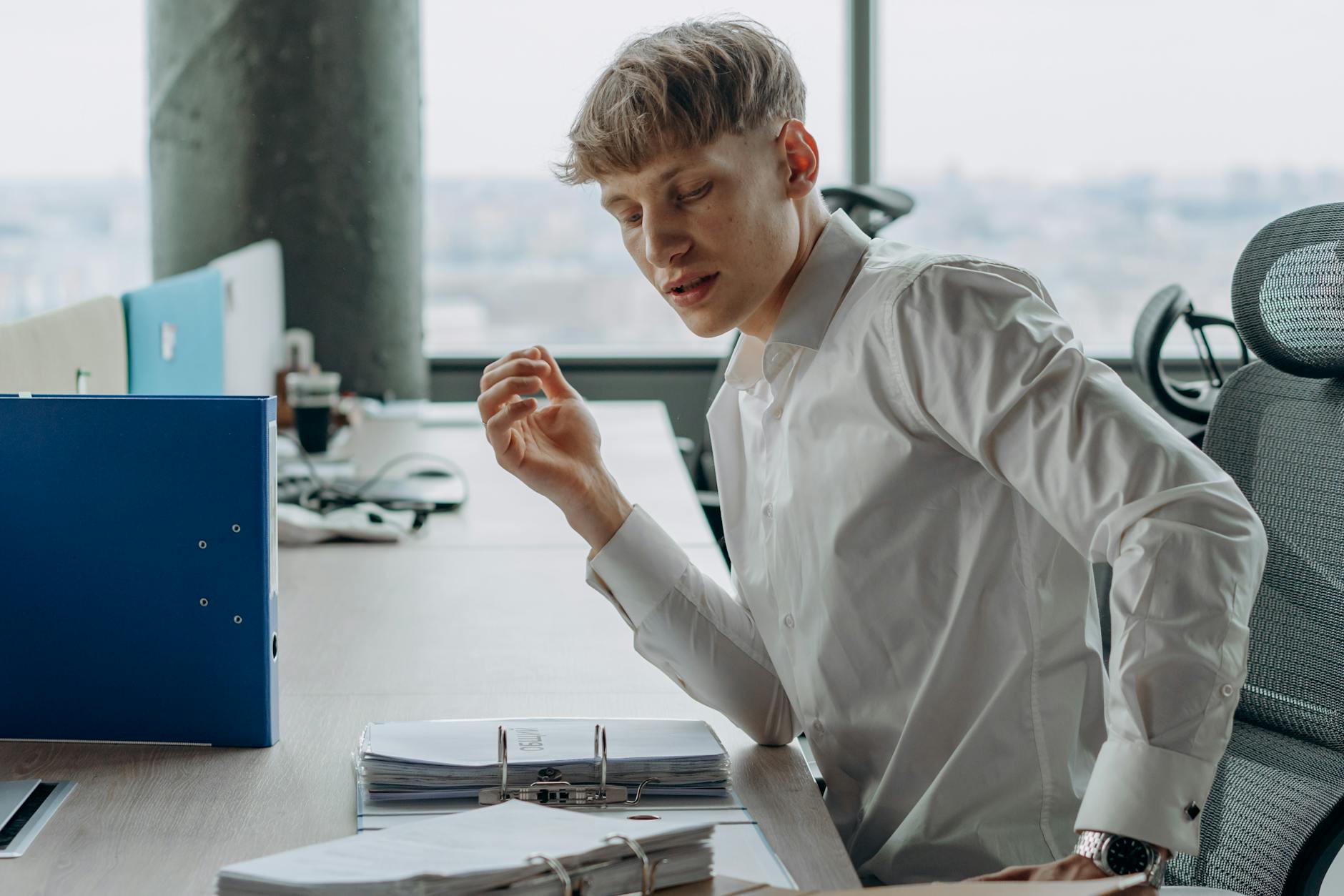 Mężczyzna przy biurku w nowoczesnym biurze czyta dokumenty