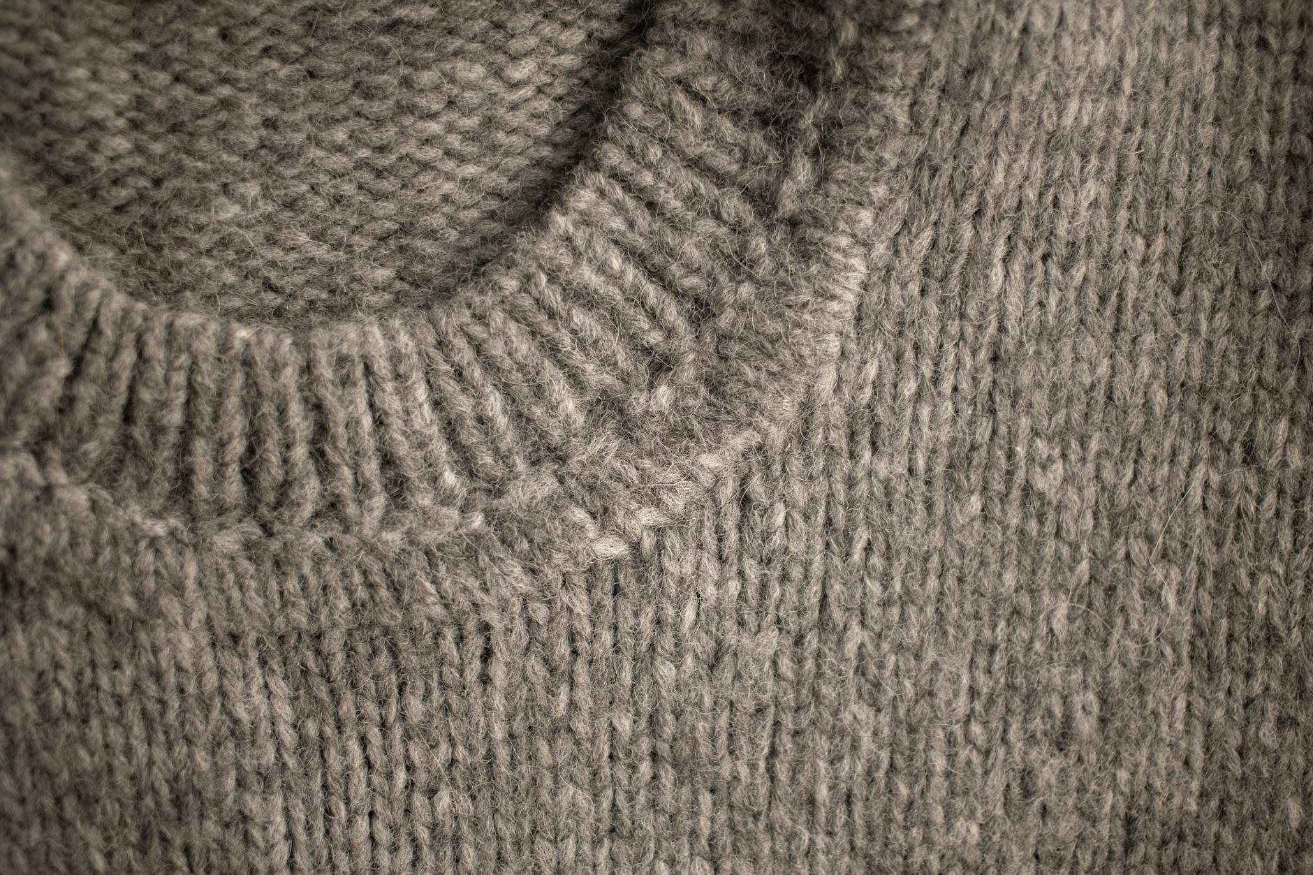 Jasnoszary kołnierz dzianego wełnianego swetra z bliska Jasnoszary kołnierz dzianego wełnianego swetra z bliska