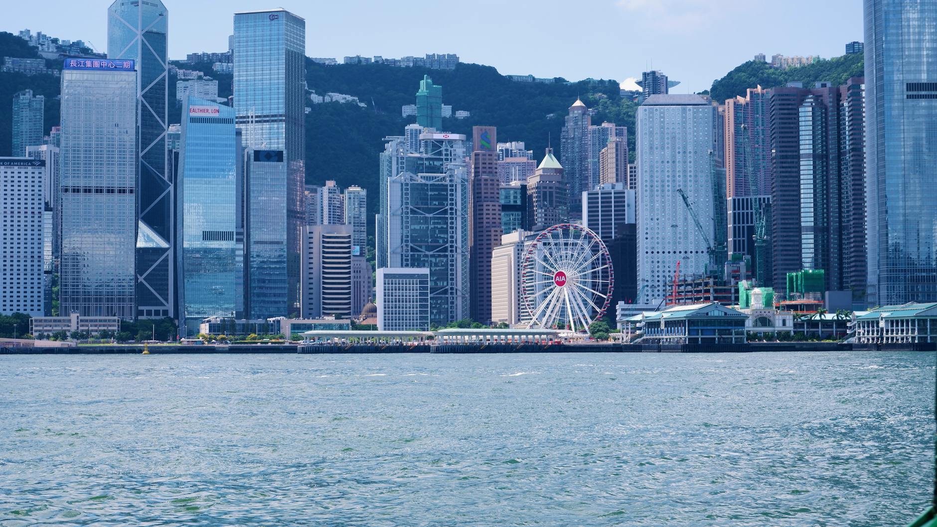 Panorama drapaczy chmur Hongkongu i diabelskiego młyna nad portem Victoria