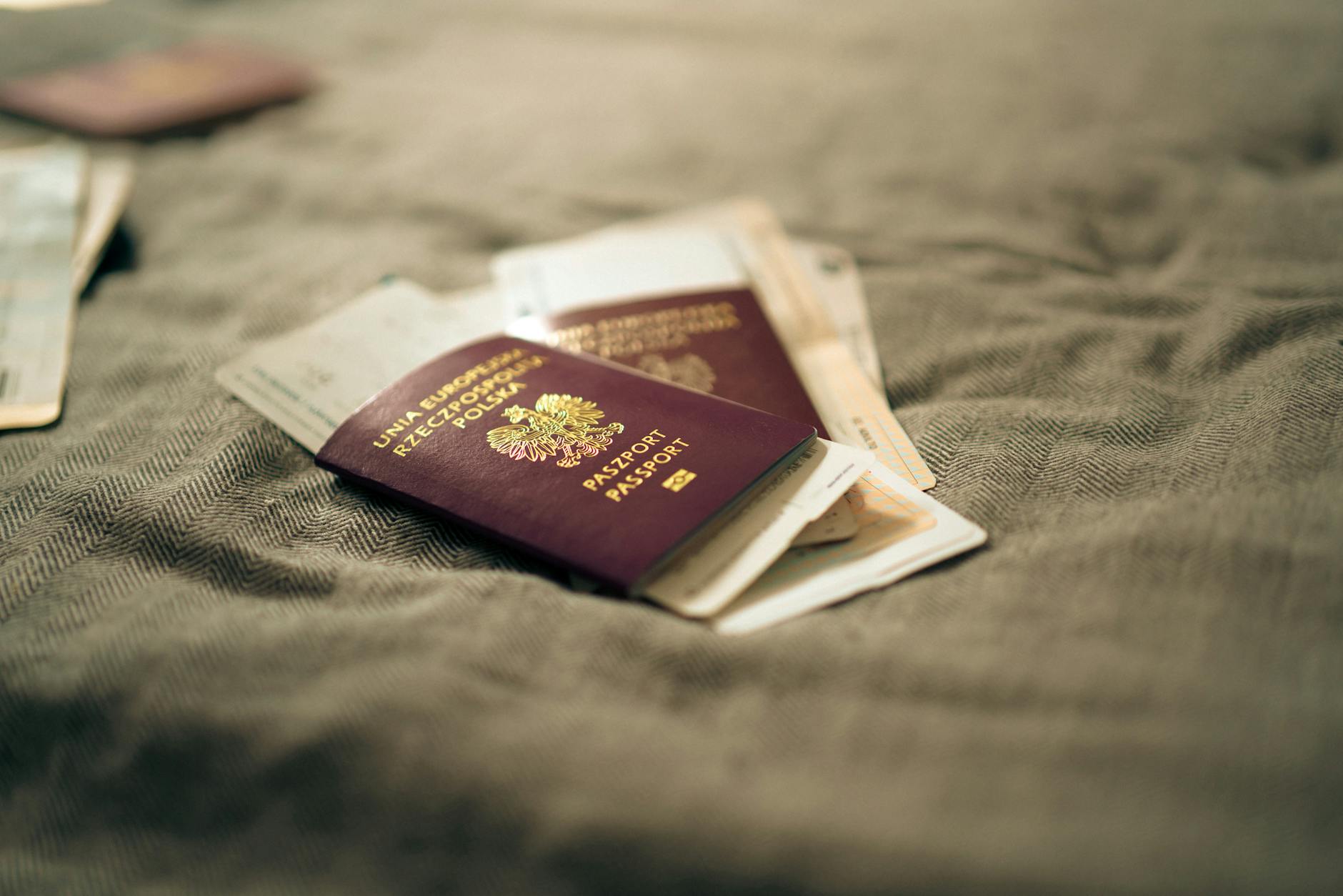 Polski paszport i dokumenty podróży leżące na materiale