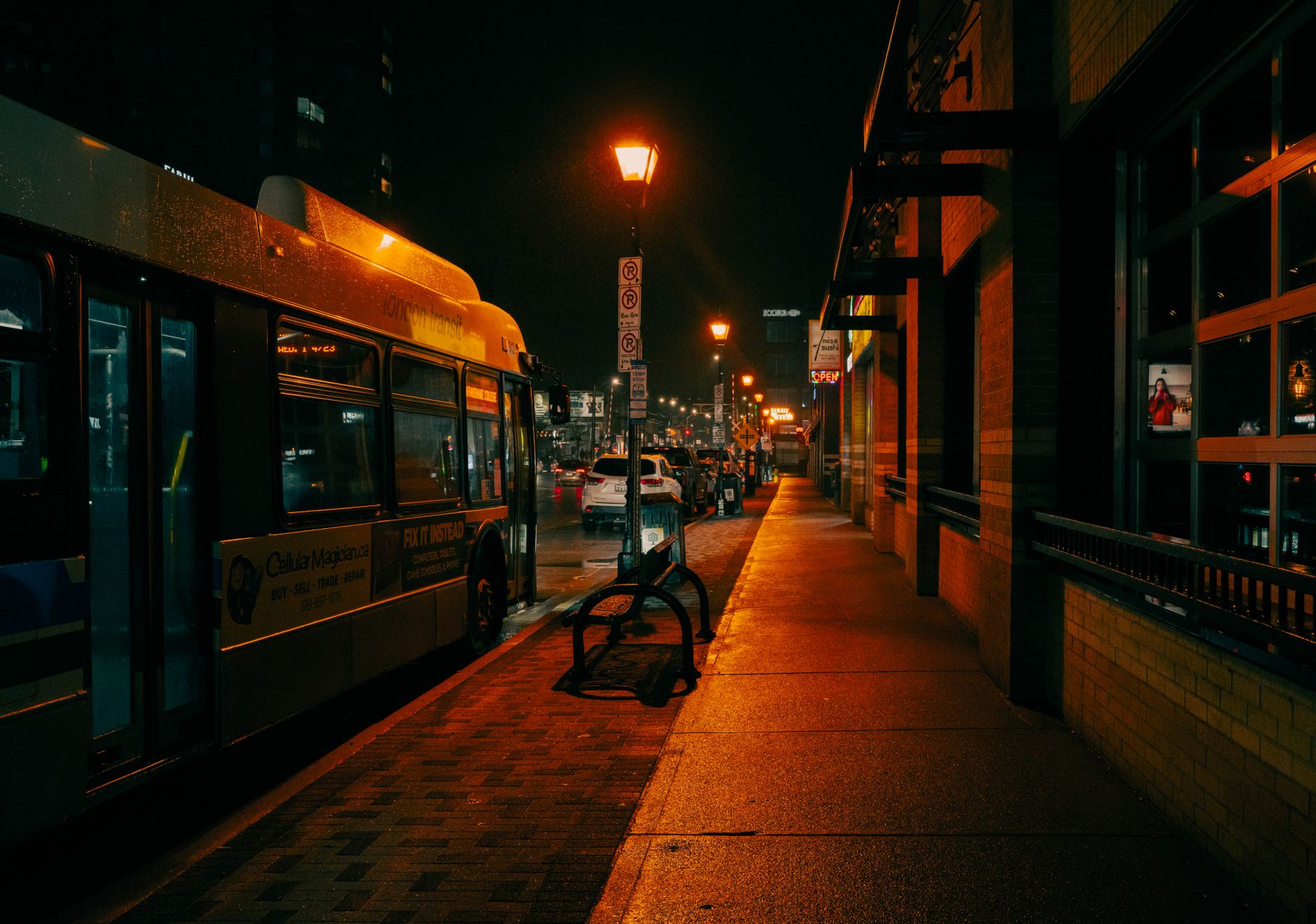 Autobus nocą na przystanku pod latarniami ulicznymi