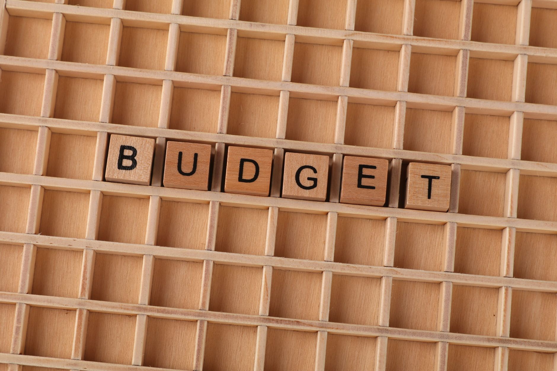 Drewniane płytki Scrabble układające słowo budget na drewnie