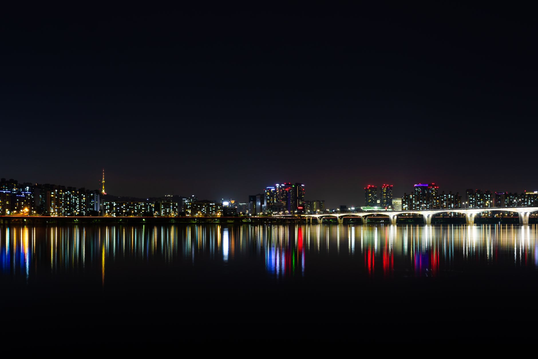 Nocna panorama oświetlonego Seulu odbita w wodach rzeki Han